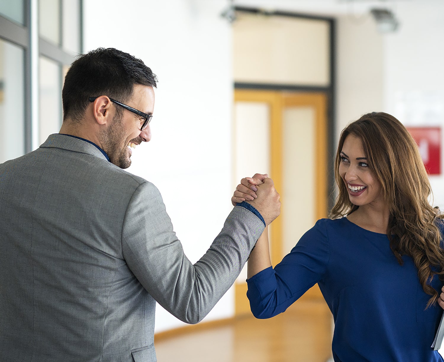 young-successful-business-people-greeting-in-company-s-office-min